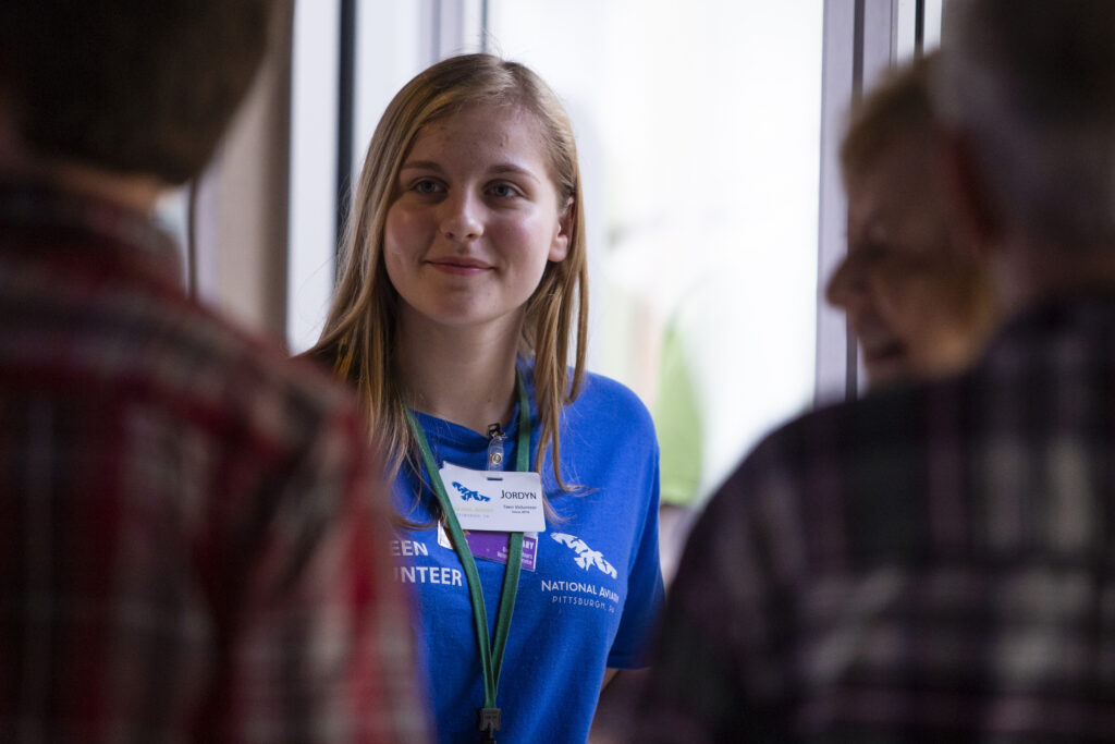 Teen Volunteer at the National Aviary ushering the Rainbow Lorikeet feeding line.