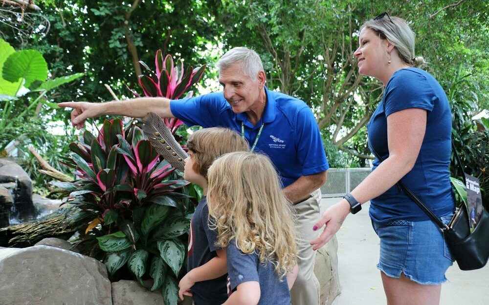 A National Aviary volunteer answers question for an enthusiastic group of children in Tropical Rainforest.