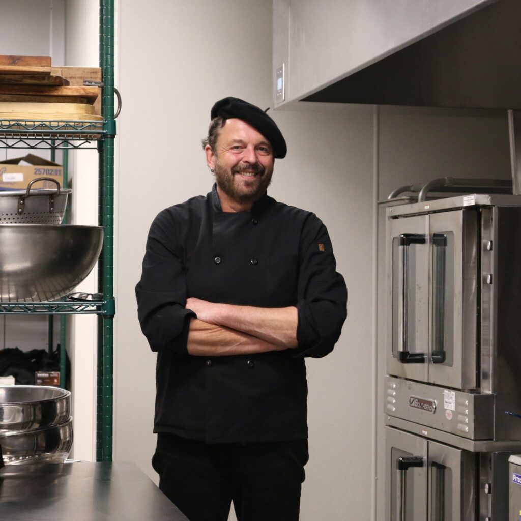 Chef Josef Kart of Atria's Specialty Catering standing within a clean, industrial kitchen.